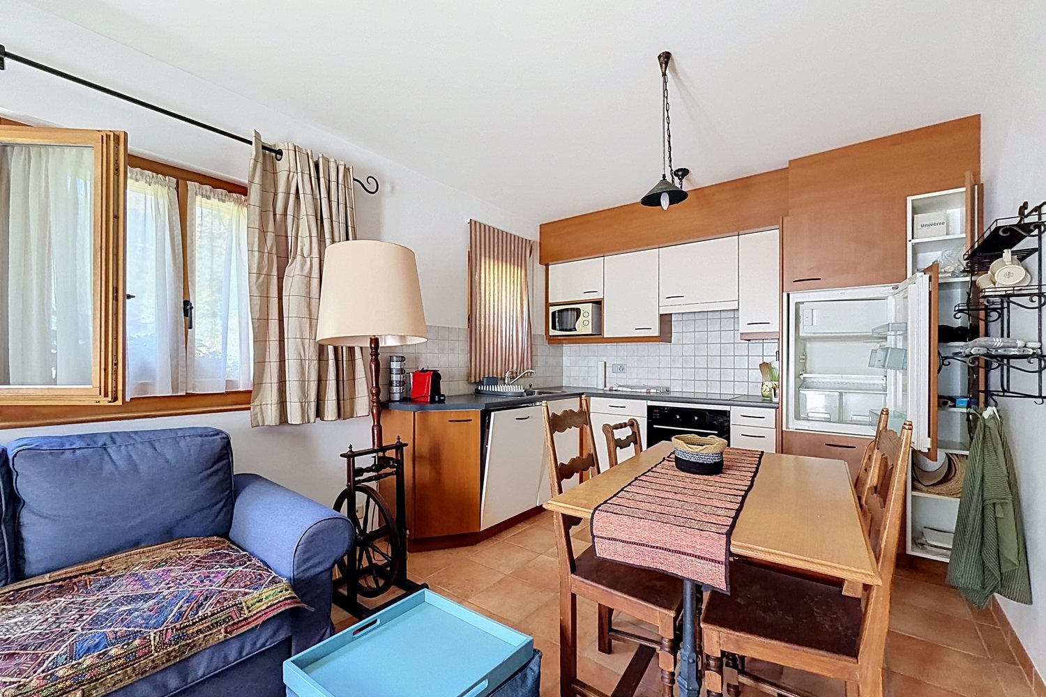 Pièce de vie du studio avec canapé, table à manger et cuisine équipée.